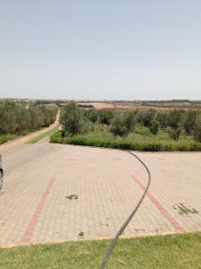 an empty parking lot with a hose on the grass at Ferme de Rayan in Safi