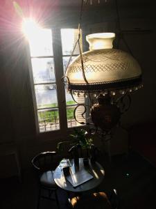 una lámpara con una mesa delante de una ventana en Casa Pellegrini - Hostel en San Pedro