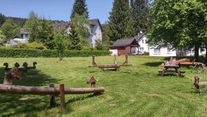 einen Park mit hölzernen Picknicktischen im Gras in der Unterkunft Apartmán Lipno in Lipno nad Vltavou