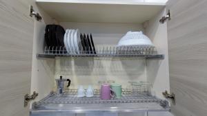 - une étagère avec des tasses et des ustensiles dans la cuisine dans l'établissement Giulia's House, à Naples