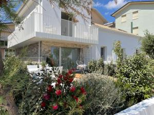 a garden in front of a house with red roses at VILLA LE AGAVI Luxory Beach Surfhouse in Bellaria-Igea Marina