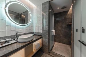 bagno con lavandino e specchio di Manju Hotel a Nantong