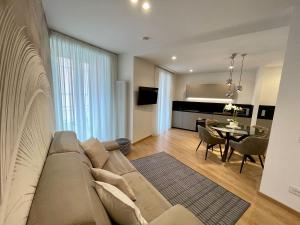 a living room with a couch and a dining room at Clavis Luxury Apartments in Chiavenna