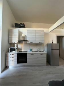 a kitchen with white cabinets and a stainless steel refrigerator at LA CASETTA in Cagliari