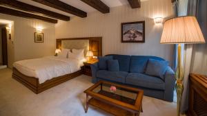 ein Schlafzimmer mit einem Bett und einem blauen Sofa in der Unterkunft Boutique Hotel ERB - Adults Only in Banská Štiavnica