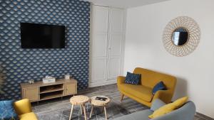 een woonkamer met een gele stoel en een tv bij Bulles d'Evasion in Avize