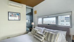 1 dormitorio con cama con almohadas y ventana en Hollywood Suites & Lofts en Buenos Aires