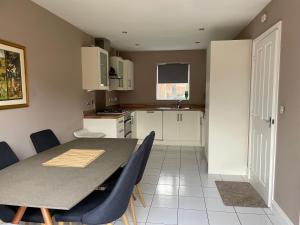 a kitchen with a table and some blue chairs at Large 2 bedroom apartment, 4 beds one 1 en-suite, Free parking Nr Chelt Elmore and Quays in Gloucester