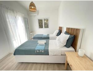 a bedroom with two beds with blue and white sheets at Hestia's House in Meganisi