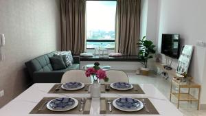ein Wohnzimmer mit einem Tisch und einem Sofa in der Unterkunft NEW Sunway Greenfield Home 2-6pax 5mins to Sunway Pyramid in Petaling Jaya