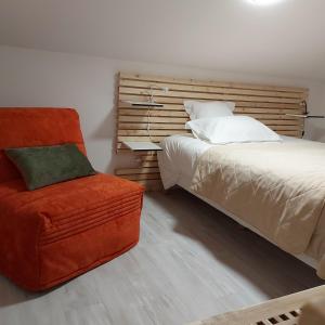 ein Schlafzimmer mit einem Bett und einem Stuhl daneben in der Unterkunft GÎTE de DRAGOUX in Bas Bouvante