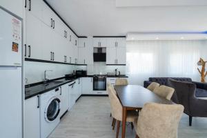 een keuken en een woonkamer met een tafel en stoelen bij Villa tiele in Fethiye