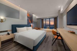 Manju Hotel في نانتونغ: غرفة نوم بسرير ابيض كبير وتلفزيون بشاشة مسطحة