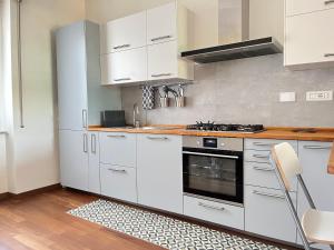 een keuken met witte kasten en een fornuis bij Stella house in La Spezia