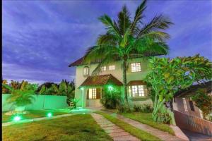 uma casa de estilo tropical com uma palmeira em Pousada Canajurê em Florianópolis
