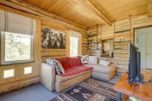 a living room with a red couch and a television at Pet-Friendly and Secluded Regina Cabin! in Regina