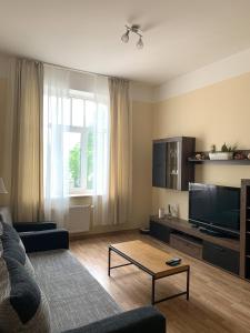 un salon avec un canapé et une télévision dans l'établissement Suitu apartments, à Liepāja
