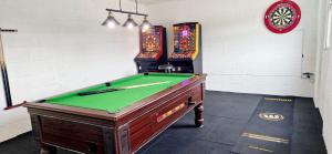 a room with a pool table and two arcade games at seven acre farm campsite in Fiskerton