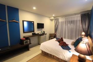 Habitación de hotel con cama y TV en Sleep Easy en Kata