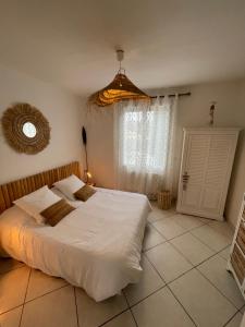 Un dormitorio con una gran cama blanca y una ventana en Au lagon de thau, en Frontignan