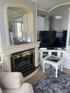a living room with a fireplace and a mirror at Amazing holiday home with sea views in Newcastle upon Tyne