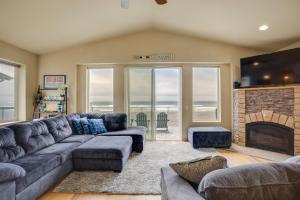 a living room with a couch and a fireplace at Gold Beach Retreat Private Hot Tub and Ocean Views! in Gold Beach