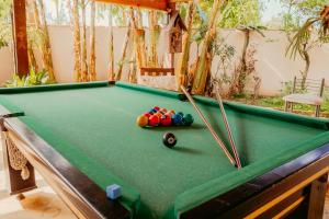 a pool table with balls and cuesticks on it at Pousada Recanto do Chef in Búzios