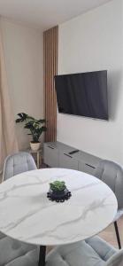 a living room with a white table and a flat screen tv at Apartament Szmaragdowy. in Siedlce
