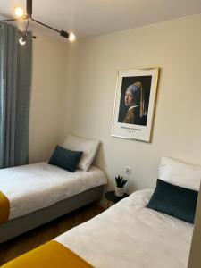 sypialnia z 2 łóżkami i zdjęciem na ścianie w obiekcie Apartament Szmaragdowy. w Siedlcach