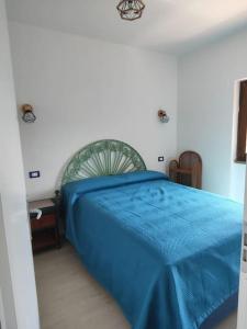 ein Schlafzimmer mit einem blauen Bett in einem Zimmer in der Unterkunft Alma Ruia apartments in Stintino