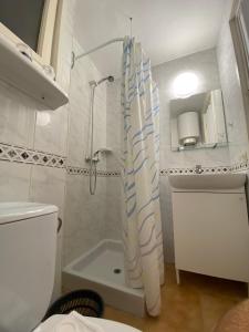 y baño con ducha y cortina de ducha. en Apartaments Margarita Sabina Pinell, en Platja d'Aro