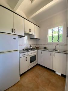 una cocina con electrodomésticos blancos y una ventana en Apartaments Margarita Sabina Pinell, en Platja d'Aro