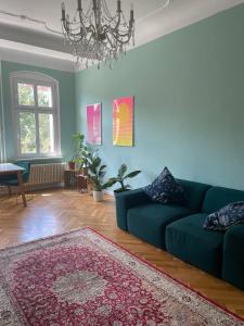 uma sala de estar com um sofá verde e um tapete em 100qm Altbau Wohnung im Prenzlauer Berg em Berlim