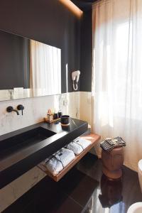 La salle de bains est pourvue d'un lavabo, de toilettes et d'un miroir. dans l'établissement Nuova Cafe' Suite, à Salice Terme
