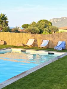 a swimming pool with two lounge chairs and a fence at Résidence de la Plage in Porto-Vecchio +22 photos