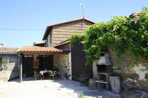 a house with a table and a grill in front of it at El Teñao in Navamorisca