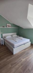 a white bed in a room with a wooden floor at Panoramic spacious 3 bedroom apartment in Sumartin