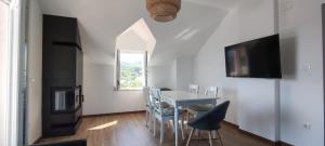 a dining room with a table and chairs and a tv at Panoramic spacious 3 bedroom apartment in Sumartin
