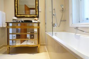 a bathroom with a sink and a tub and a mirror at Ashburn Hotel in London