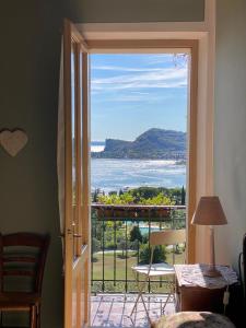 una porta che conduce a un balcone con vista sull'oceano di Villa Schindler a Manerba del Garda