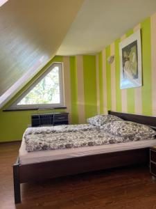 a bedroom with green and yellow striped walls and a bed at Villa Vip in Trzęsacz