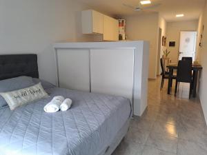1 dormitorio con 1 cama con 2 almohadas blancas en Kalay Home Resistencia-Alquiler Monoambiente temporario en Resistencia