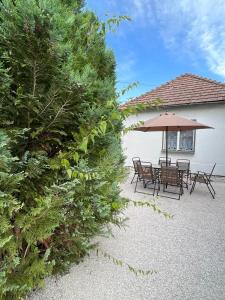 a patio with a table and chairs and an umbrella at Dom ALEX pri kúpalisku Thermalpark in Dunajská Streda