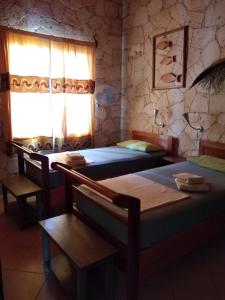 1 dormitorio con 2 camas y ventana en Casita Solemar direkt am Atlantik en Calheta Do Maio