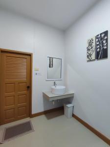 łazienka z umywalką, lustrem i drzwiami w obiekcie DeliZia de Villa เดลิเซีย เดอ วิลล่า w mieście Satun