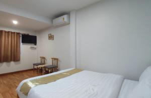 sypialnia z łóżkiem, telewizorem i krzesłami w obiekcie DeliZia de Villa เดลิเซีย เดอ วิลล่า w mieście Satun