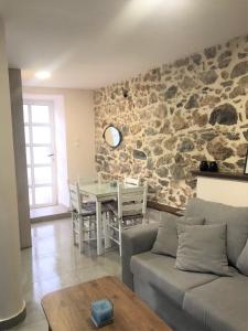 a living room with a couch and a stone wall at METAXIAS HOUSE in Leonidion