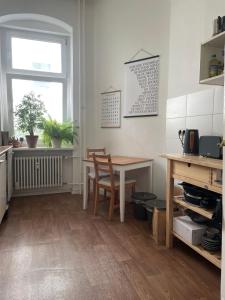 kuchnia ze stołem i krzesłami oraz oknem w obiekcie 100qm Altbau Wohnung im Prenzlauer Berg w Berlinie