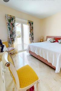 1 dormitorio con 1 cama y 1 silla amarilla en VILLA MAIA Mijas Golf, en Santa Fe de los Boliches