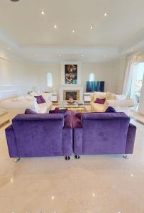 una gran sala de estar con 2 sofás morados en VILLA MAIA Mijas Golf, en Santa Fe de los Boliches